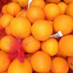 A bunch of oranges in a net.