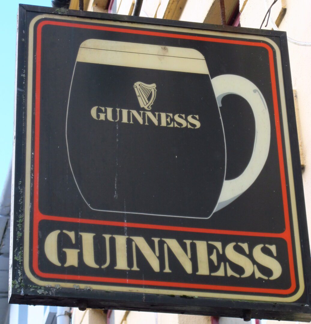 A guinness sign on the side of a building.