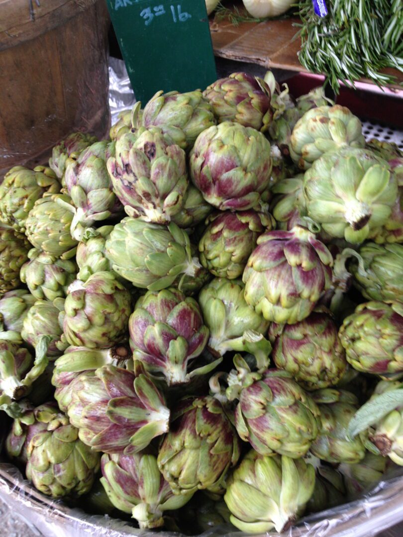 A bowl of artichokes on a table.