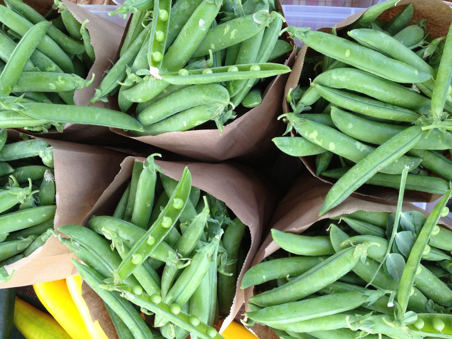 A bunch of green peas in a paper bag.