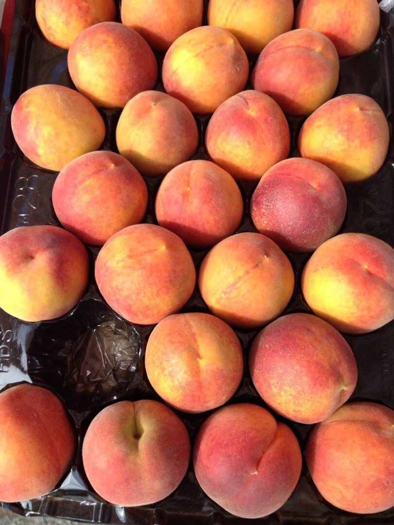 A tray of peaches sitting on a table.