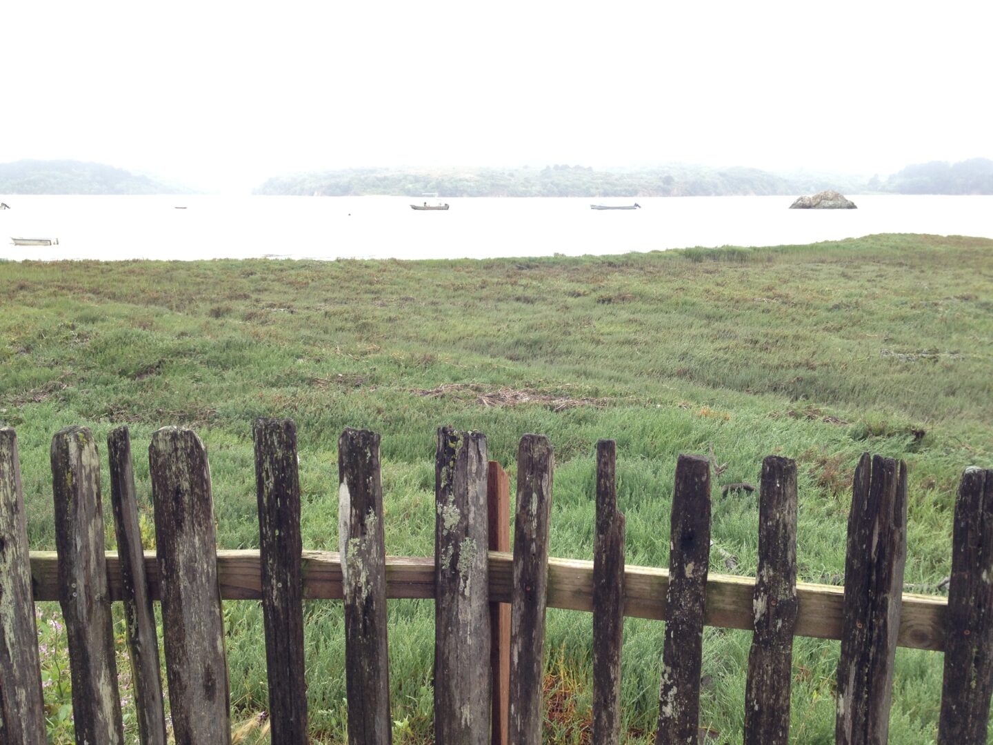 A wooden fence next to a body of water.
