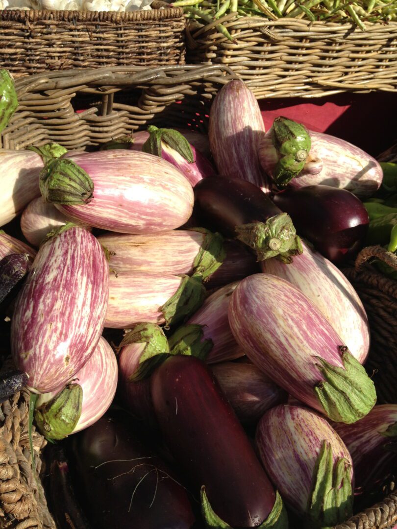 A bunch of eggplants in a wicker basket.