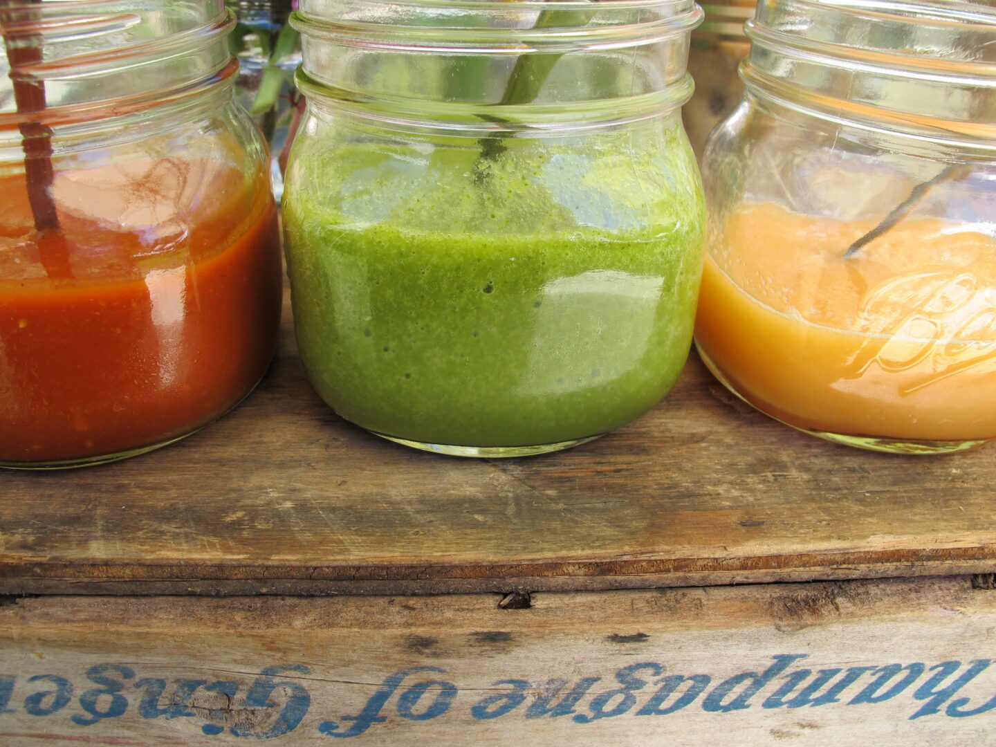 Four mason jars filled with different kinds of juices.