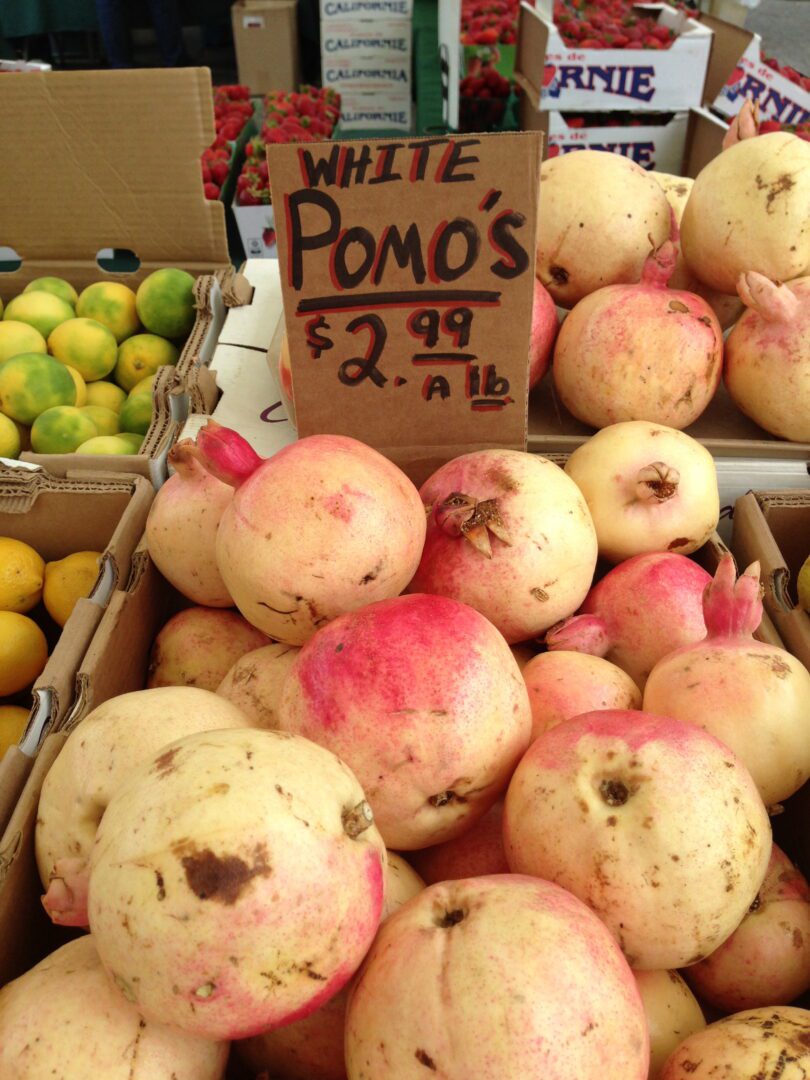 A bunch of pomegranates and lemons at a market.