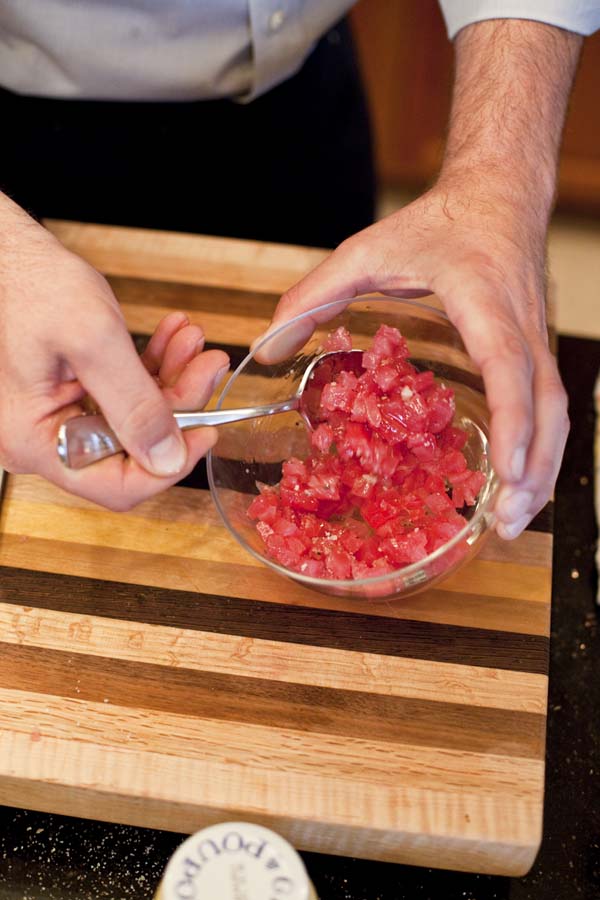 A man is slicing a piece of meat into a bowl.