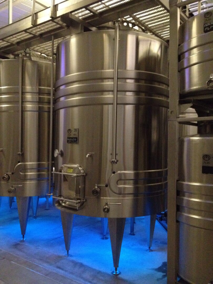 A group of stainless steel tanks in a room.