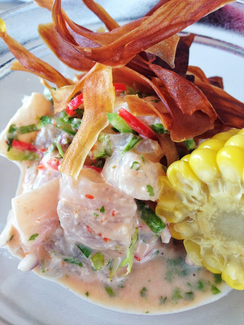 A plate of food with a corn on the cob.