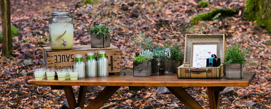 A table with bottles and jars in the woods.