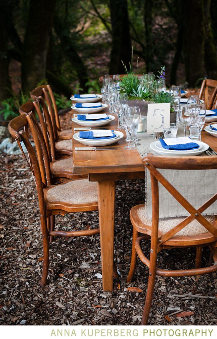 A wooden table set up in the woods.