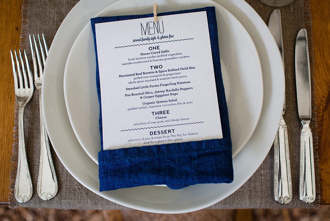 A table setting with a blue napkin and silverware.