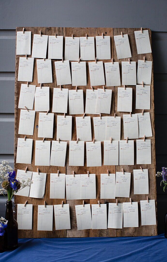 A wooden board with place cards hanging on it.