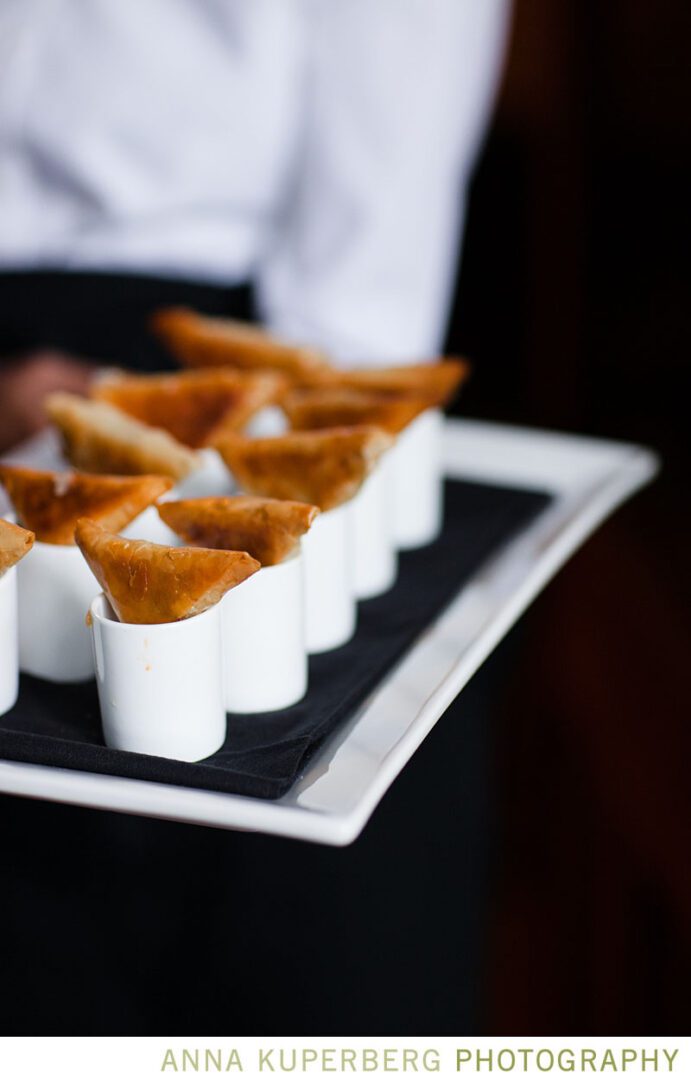 A waiter is holding a tray of appetizers.