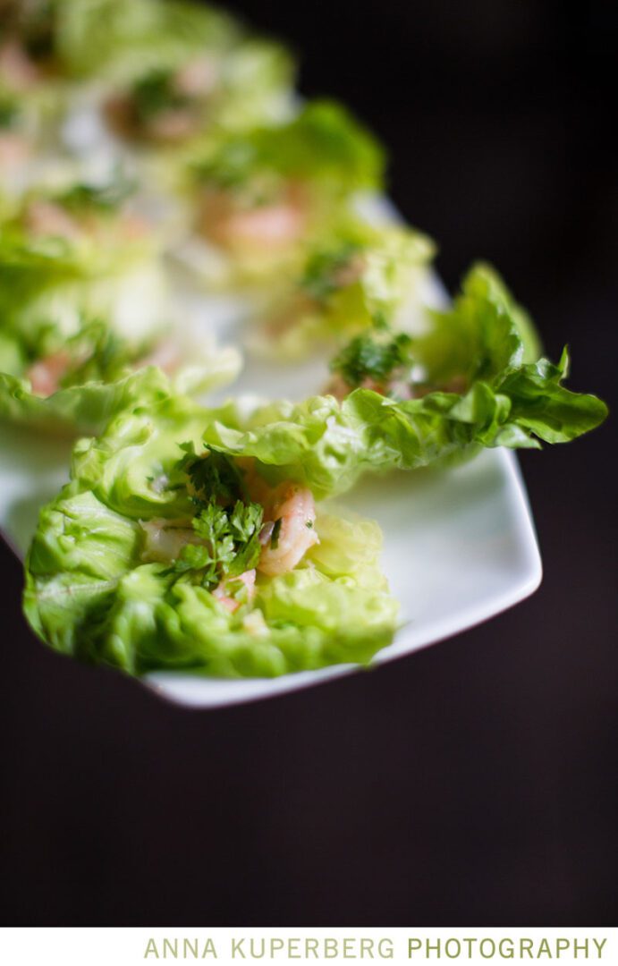 A white plate with shrimp and lettuce on it.