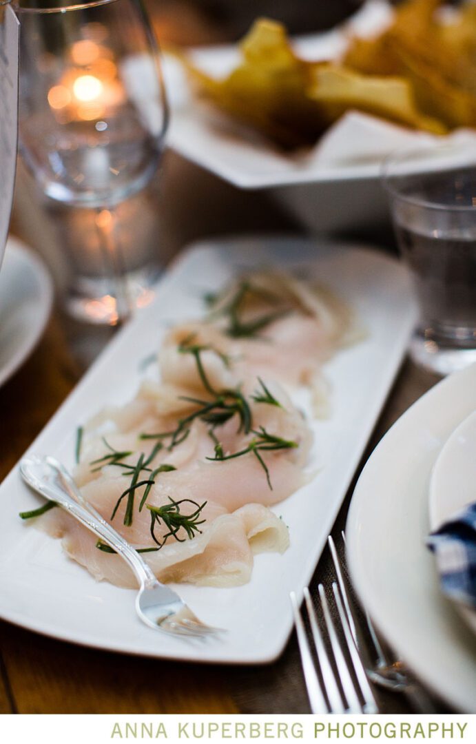 A white plate with a piece of fish on it.