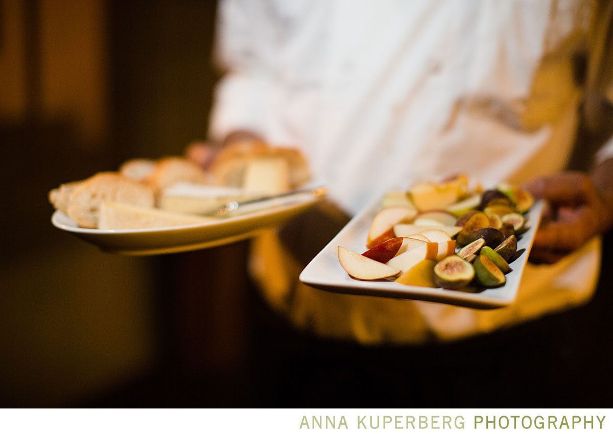 A waiter is holding trays of food.