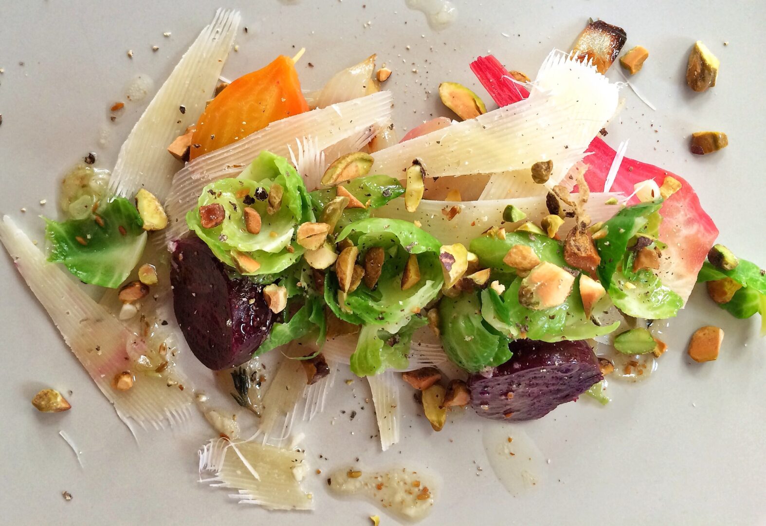 A plate with vegetables and nuts on it.