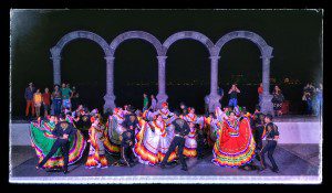 A group of mexican dancers on stage at night.