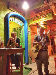A man and a woman playing guitar in a restaurant.