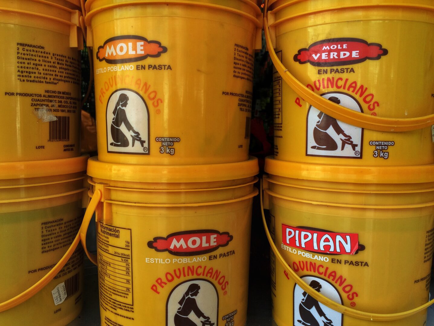 Several yellow buckets are lined up next to each other.