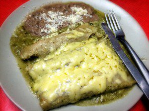 Mexican enchiladas on a plate with a fork.