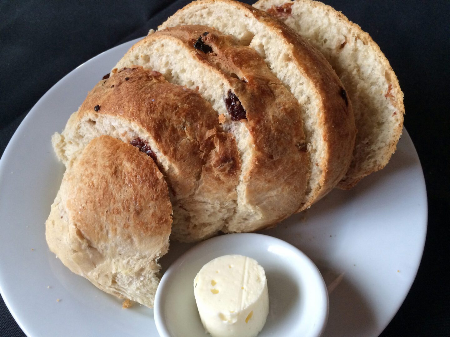 A slice of bread with butter on a plate.
