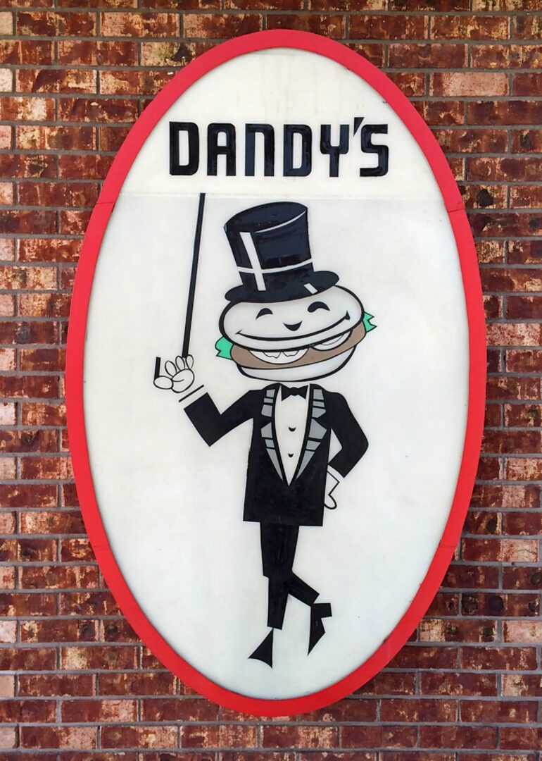 A sign that says dandy's on a brick wall.