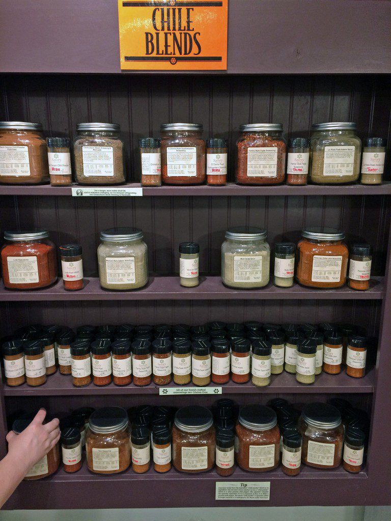 A shelf with many jars of spices.