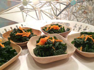 Four bowls of kale and carrots on a table.