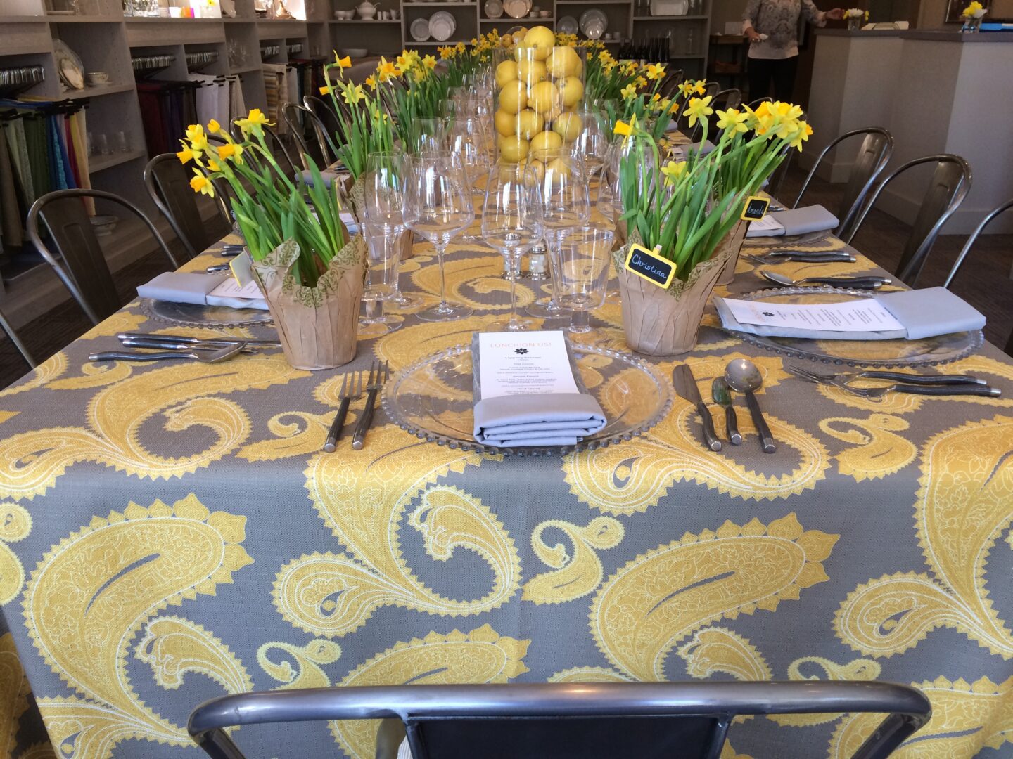 A table with a yellow and gray paisley tablecloth.