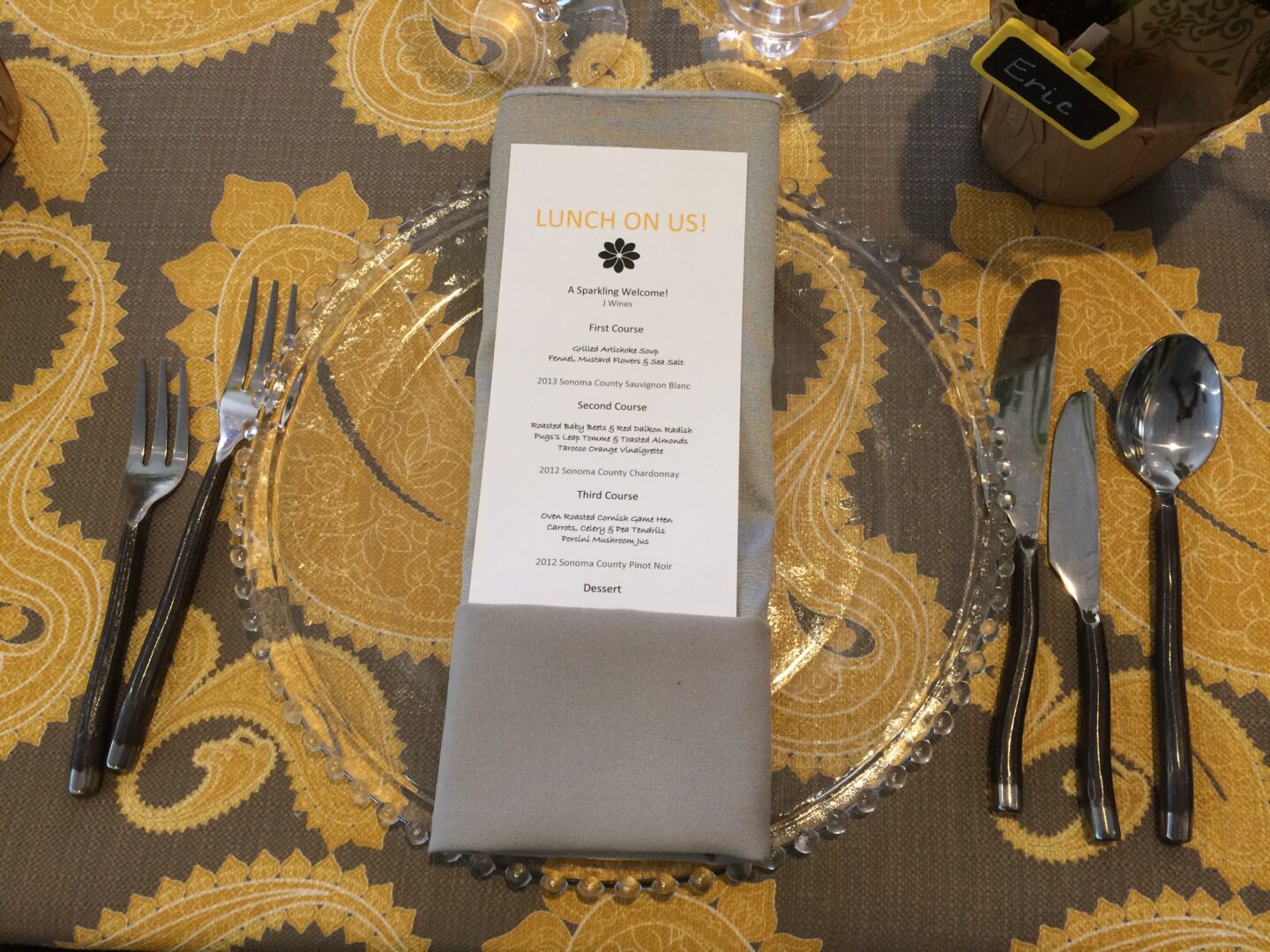 A place setting with a menu and silverware.