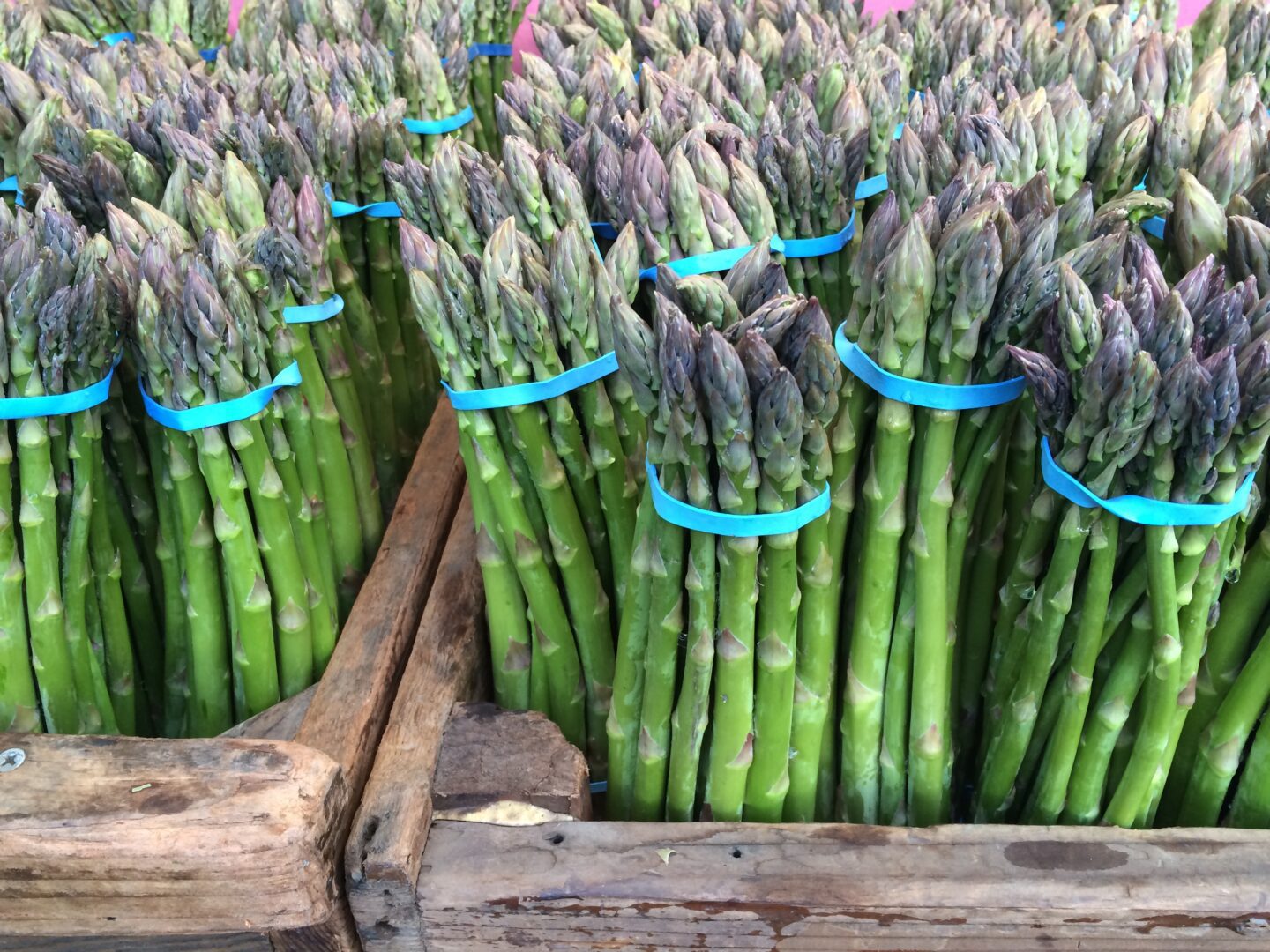 A bunch of asparagus in a wooden crate.