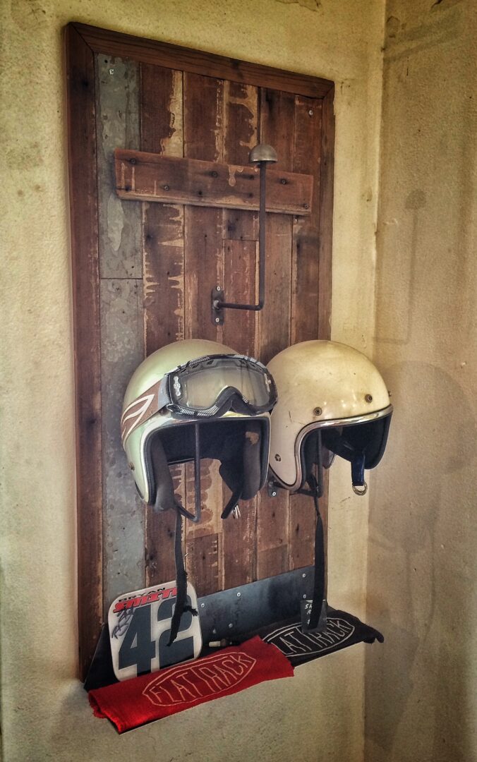 Two helmets hanging on a wall.
