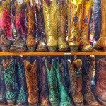 A row of cowboy boots on a shelf.