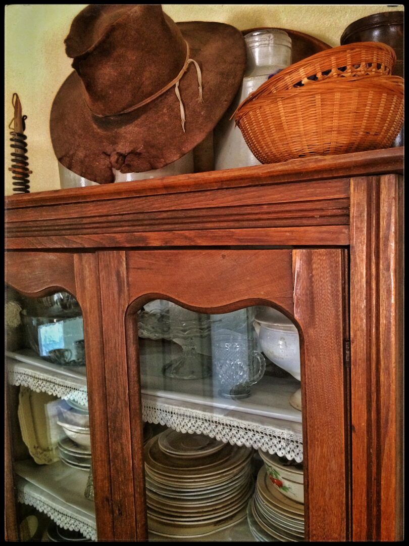 A wooden hutch with a cowboy hat on it.