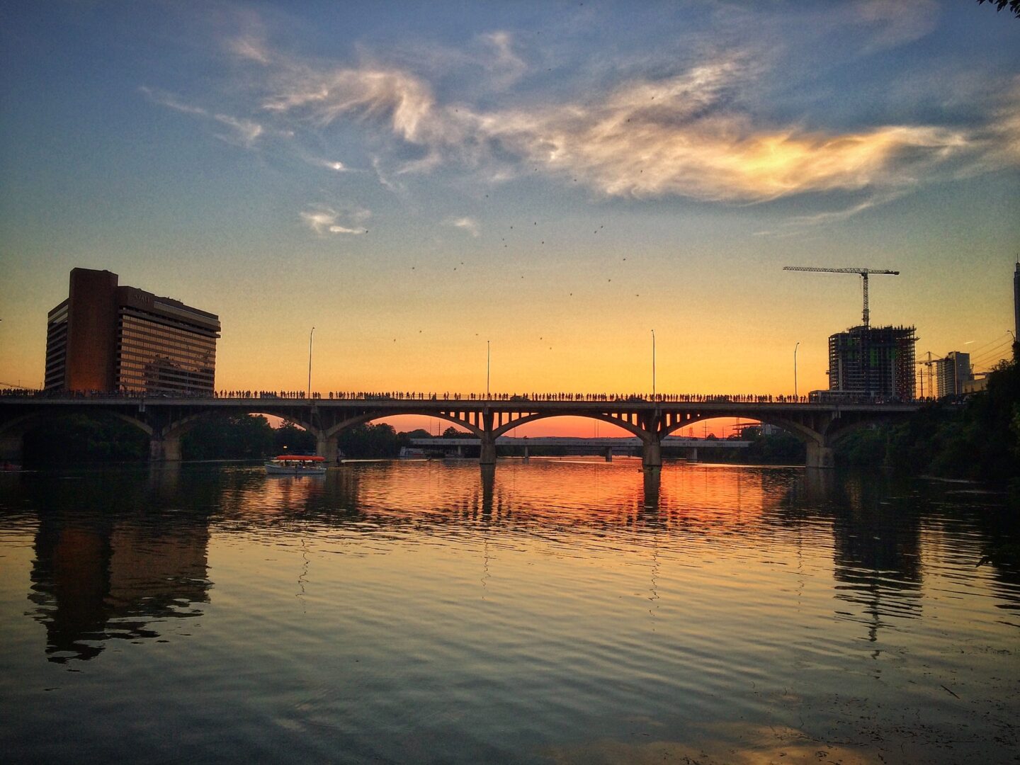 A bridge over a body of water at sunset.