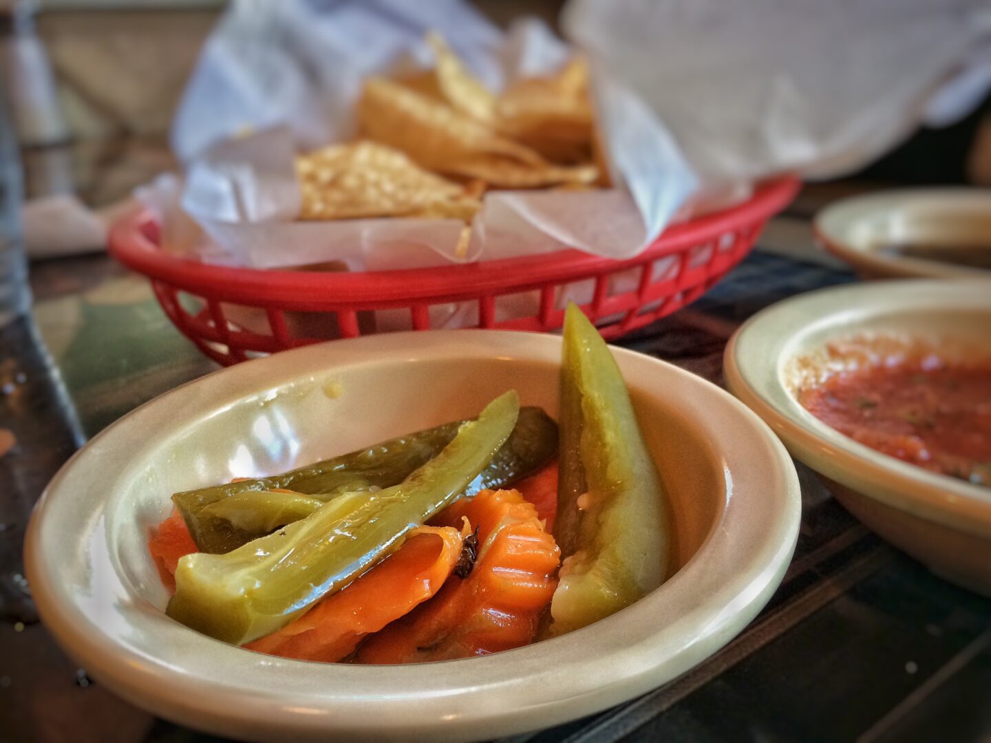 A bowl of pickles on a table.