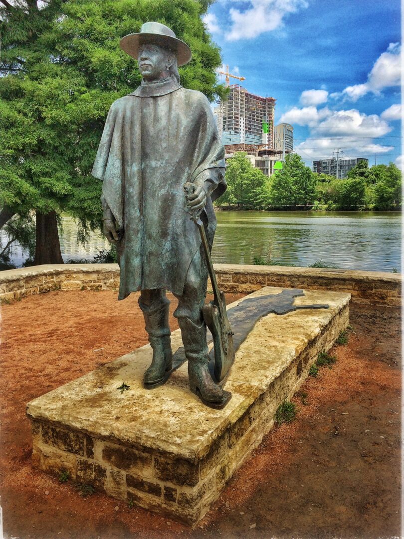 A statue of a man with a hat and a shovel.