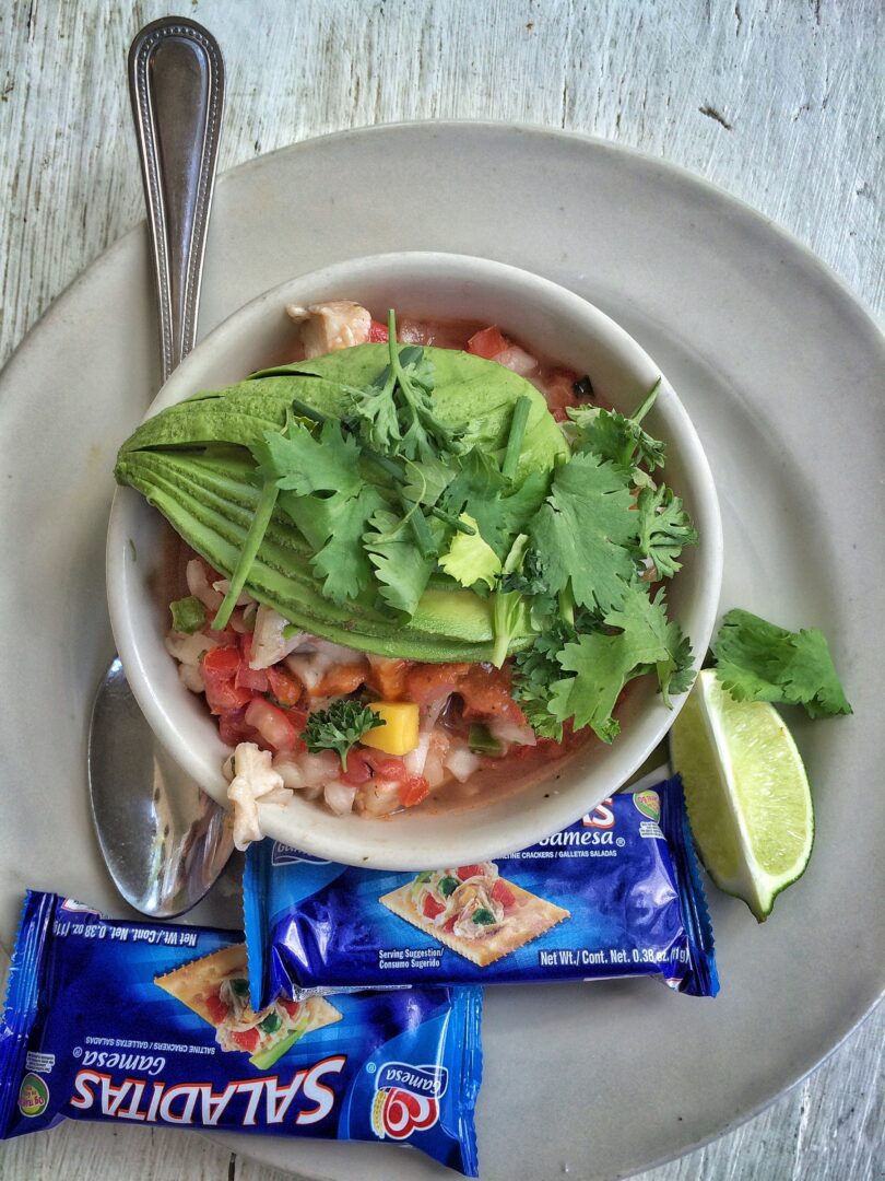 A bowl of guacamole and tortilla chips on a plate.