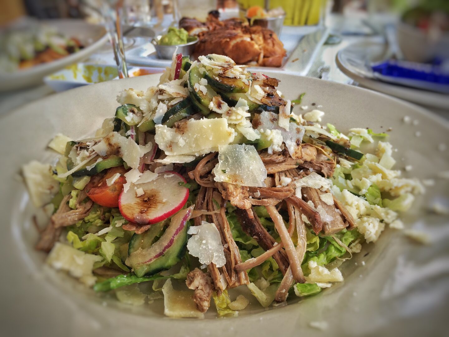 A white plate with a salad on it.