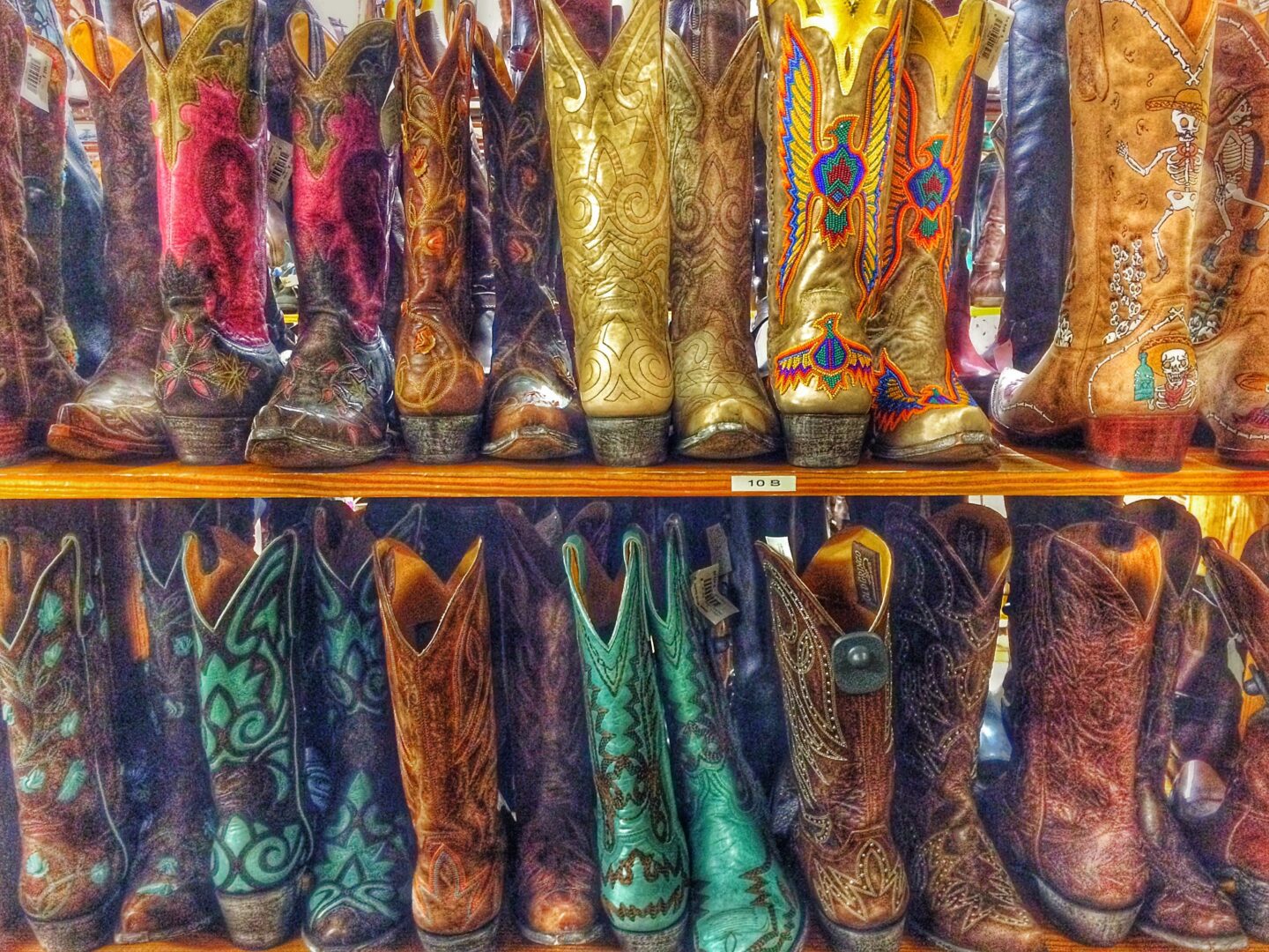 A row of cowboy boots on a shelf.