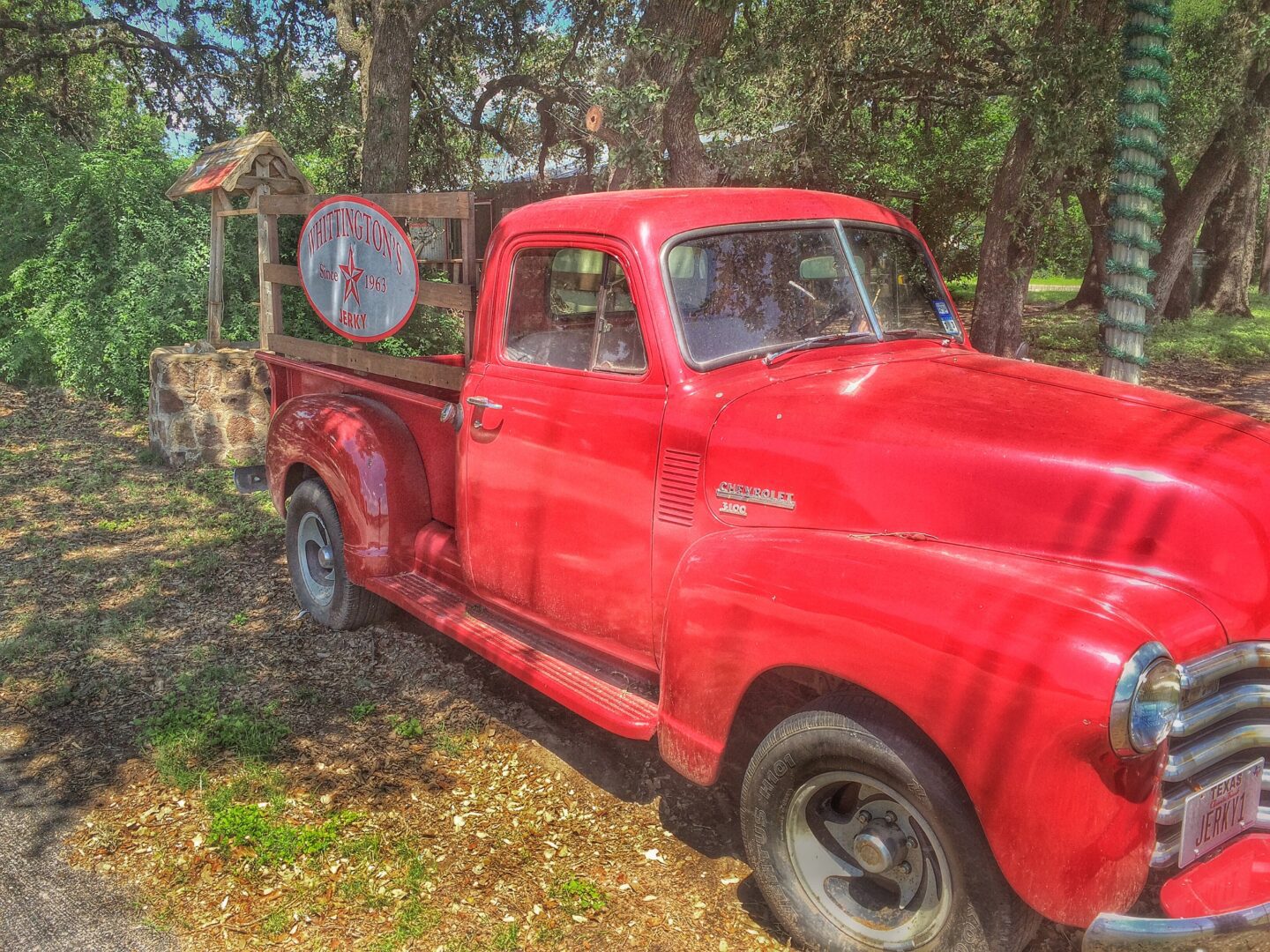 A red pickup truck parked on the side of the road.