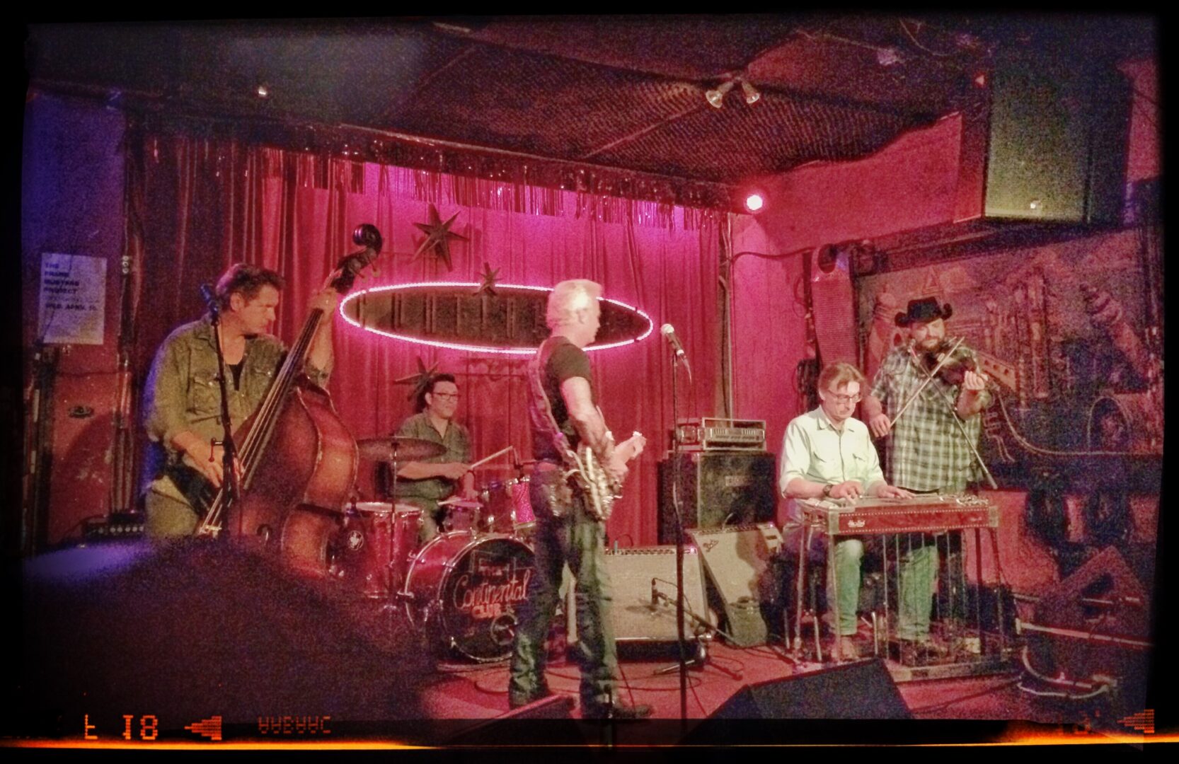 A group of people playing music in a bar.