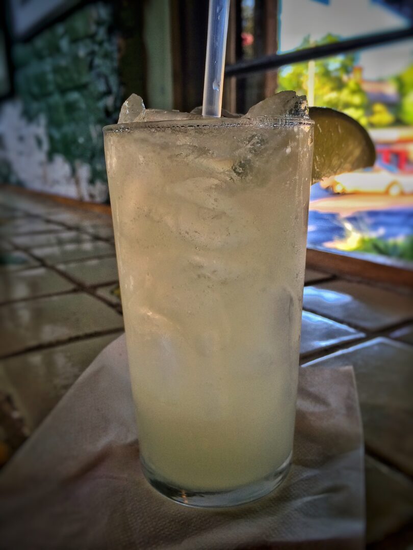 A margarita with a straw sitting on a table.