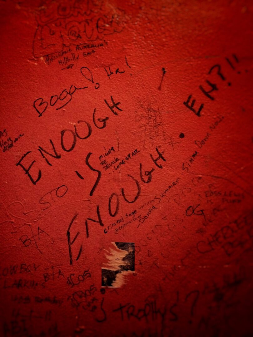 A red wall with writing on it that says enough is enough.