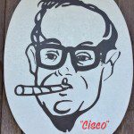 A sign with a man in glasses smoking a cigarette.