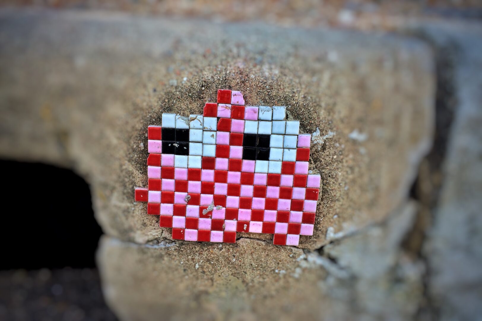 A red and white checkered pixel art on a wall.