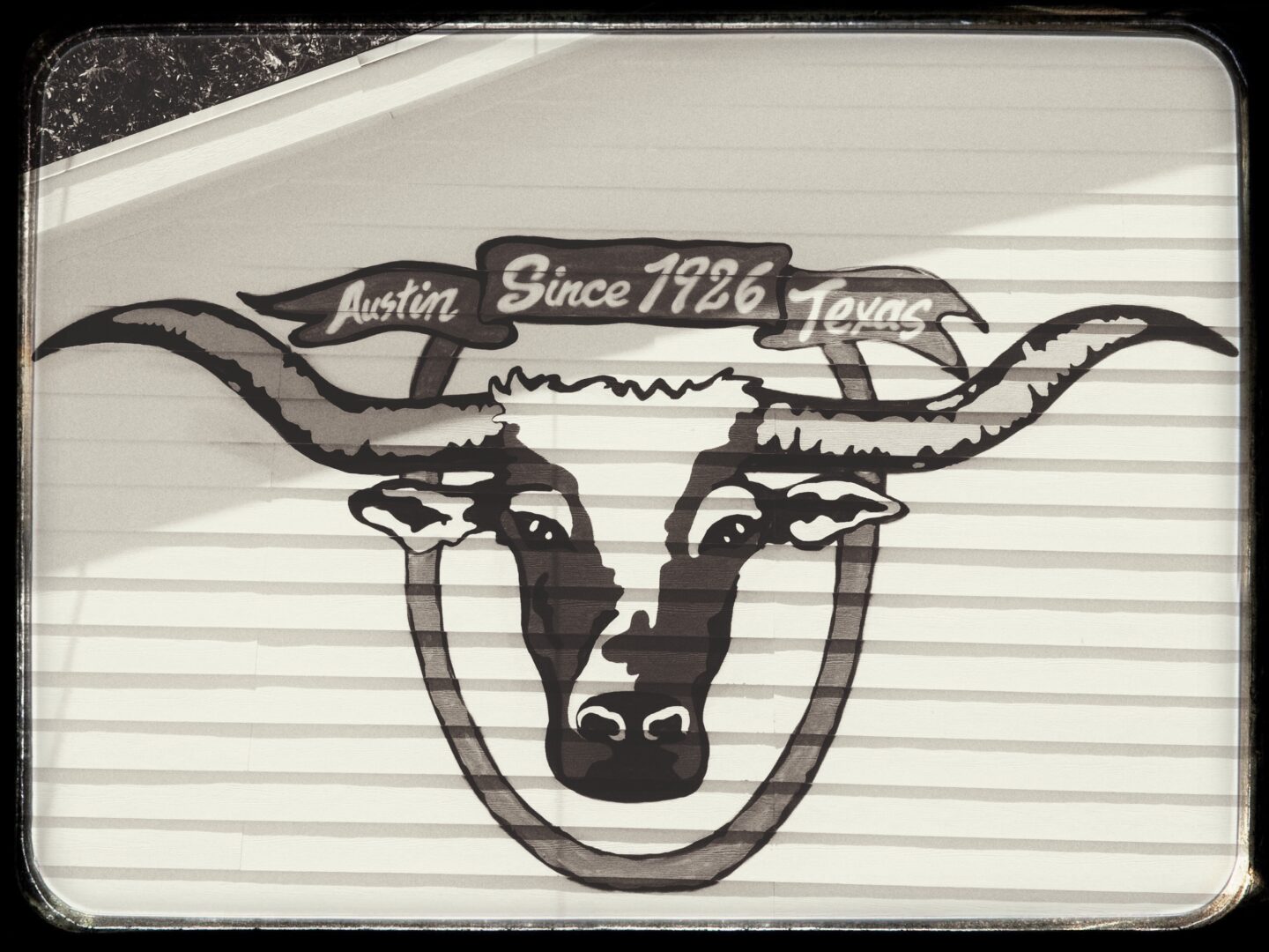 A cow with horns on the side of a building.