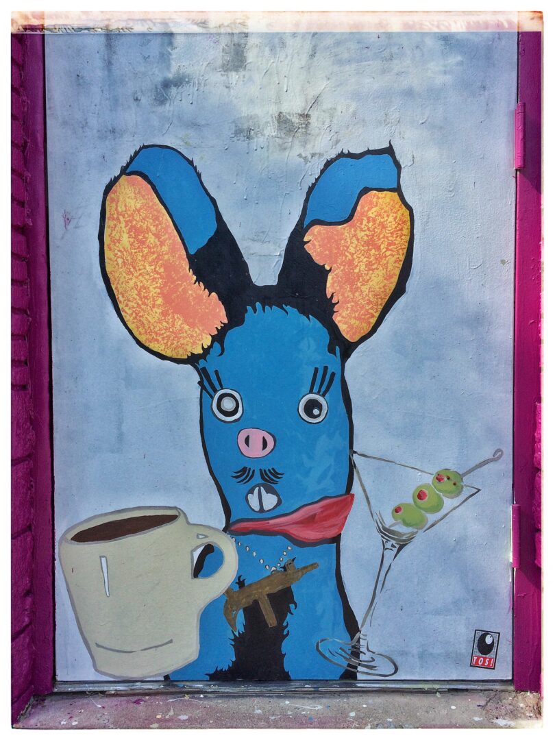 A painting of a blue bunny with a martini and a cup of coffee.