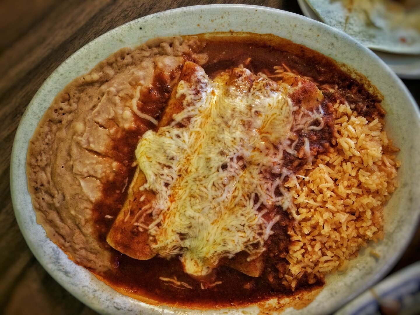 A plate of mexican food with rice and enchiladas.